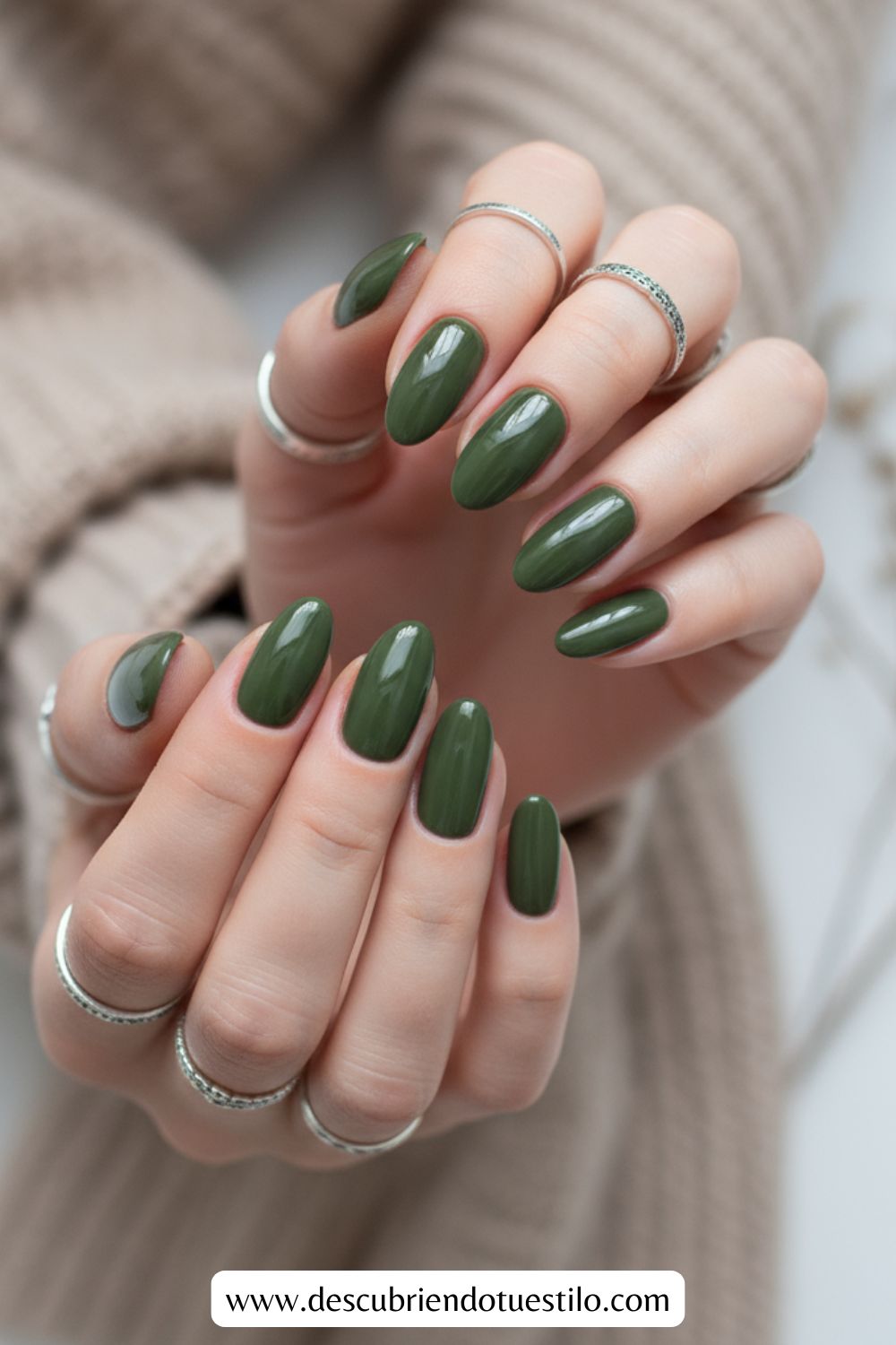 Primer plano de unas manos con uñas otoñales en forma de almendra pintadas de verde oliva